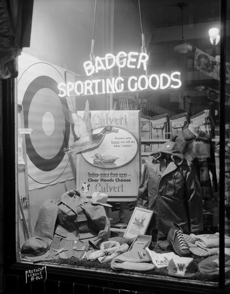 Calvert liquor sign and sporting goods displayed in the window of Badger Sporting Goods store, 418 State Street.