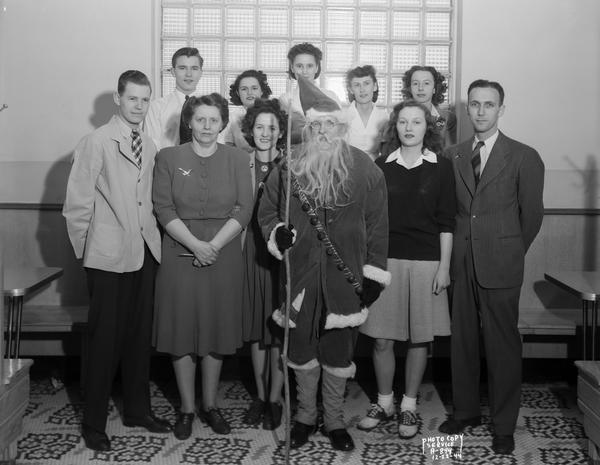 Group portrait of ten employees of the Rennebohm's drugstore #12 at  2526 Monroe Street, posed at a Christmas party with Santa Claus.