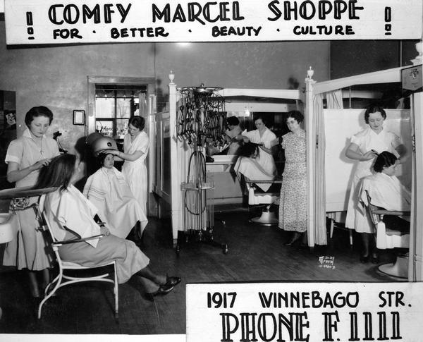 Five beauty operators and four customers in the Comfy Marcel Shoppe, 1917 Winnebago Street, beauty parlor. Includes advertising text: "For better beauty culture."