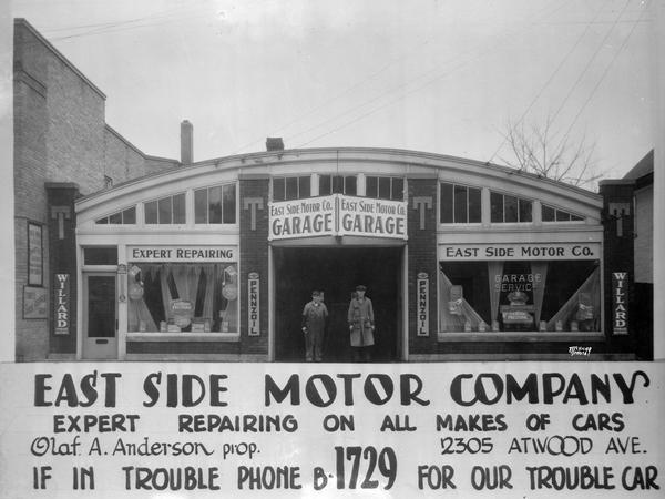 Two men are standing in the doorway of the East Side Motor Company garage, 2305 Atwood Avenue, featuring Willard storage batteries, Pennzoil, and Eveready and Prestone. Advertising text reads: "Expert repairing on all makes of cars," "Olaf A Anderson, prop., If in trouble phone B-1729 for our trouble car."
