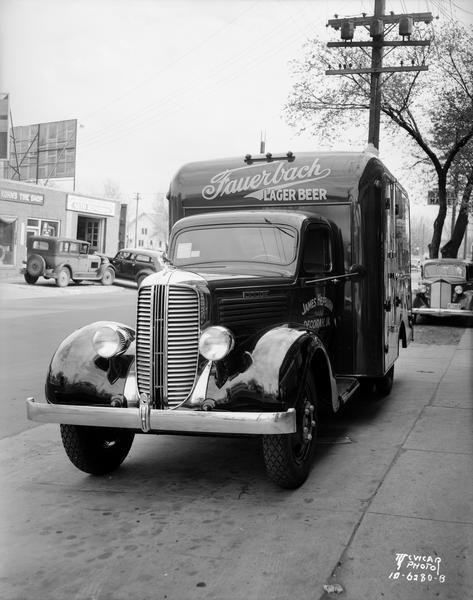 Front view of Fauerbach Lager Beer truck, with James Hepburn, Distributor, Decorah, Iowa painted on the cab, outside of the Ideal Body Company, 502 S. Park Street. Advertising on side reads: "Quality Since 1848." In the background is the Kohn Tire shop, located at 505 South Park Street.