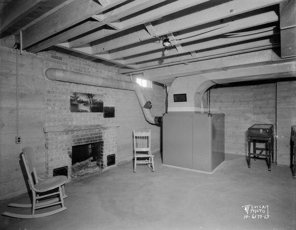 Furnace installation by Hefty Sales Co., in a recreation room with a fireplace and pinball machine.