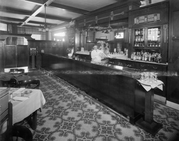 Cardinal Hotel Bar with a male bartender shaking a cocktail shaker.