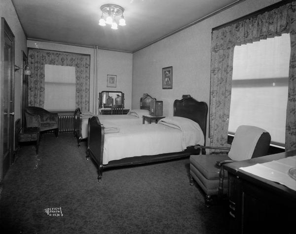 Interior view of Park Hotel hotel room with twin beds. The shades are pulled closed.