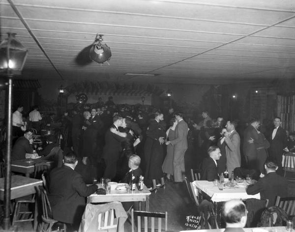 Interior view of Club Marco (formerly French Village), Oregon Road (2323 S. Park Street), with couples dancing, and people sitting at tables in the foreground.