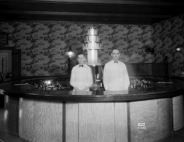 Two bartenders are standing in the middle of the circular bar at the Park Hotel.