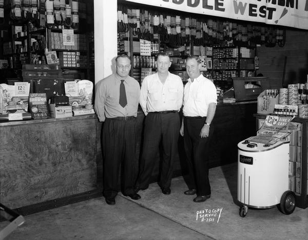 Winnebago Auto Parts Company, 103 North Park Street. Three salesmen are in the store in front of a display of auto parts.