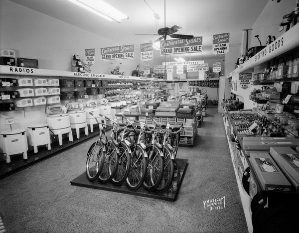 Continental Store grand opening sale, 6 North Street. Interior view showing counters and merchandise, washing machines, bicycles, auto parts and cash register.