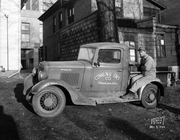 Conklin & Sons International pickup truck No. 13, with man sitting on back fender.