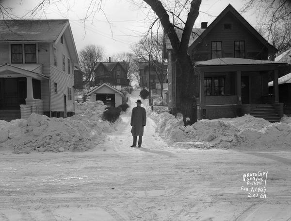 Accident scene between truck driven by Clyde Holmes and Donald Marking, age eight, who was struck and killed while sledding. View shows the alley between 1010 and 1004 Garfield Street where the boy was sledding. Ted Field, attorney, is standing in the alley.