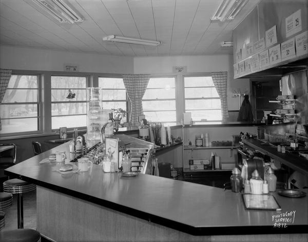 Interior of Kober's Dairy Bar drive-in restaurant, 2237 Sherman Avenue, with octagonal shaped counter. Windows are along the wall in the background.