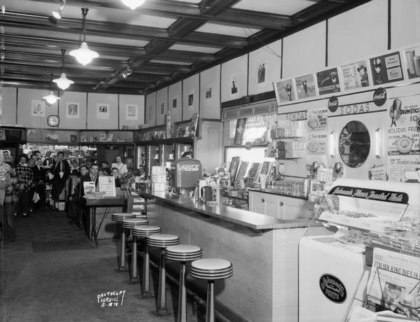Interior of Kreb's Pharmacy, with the soda fountain in the foreground, and customers are in booths in the background.