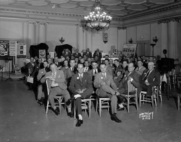 Group portrait of men attending an informational meeting of the Wisconsin Power & Light Company, Central Wisconsin Adequate Wiring Bureau at the Loraine Hotel. "See to it that your home has a large enough service entrance, enough circuits of large enough wire, also enough outlets and switches."