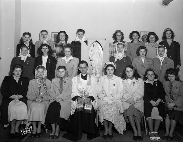 Group portrait of twenty-one women, members of the Sodality, and one priest, taken at Holy Redeemer Catholic Church, 128 West Johnson Street.