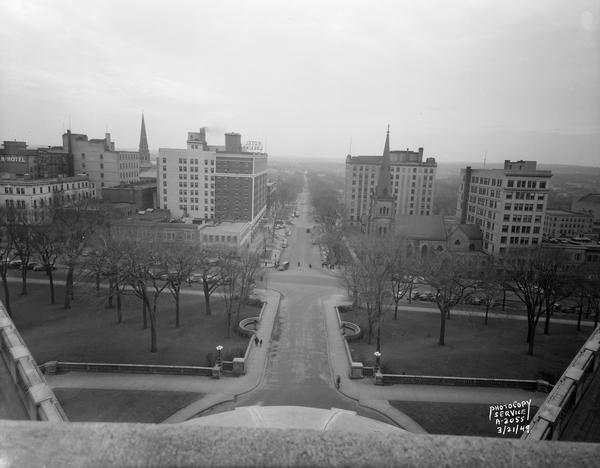 View from State Capitol, showing Carroll Street side of the Square and West Washington Avenue. Buildings from left to right include Park Hotel, St. Raphael's Catholic Church, Loraine Hotel, Wisconsin Power & Light Building, Grace Episcopal Church, Gay Building and Madison Gas & Electric Building.