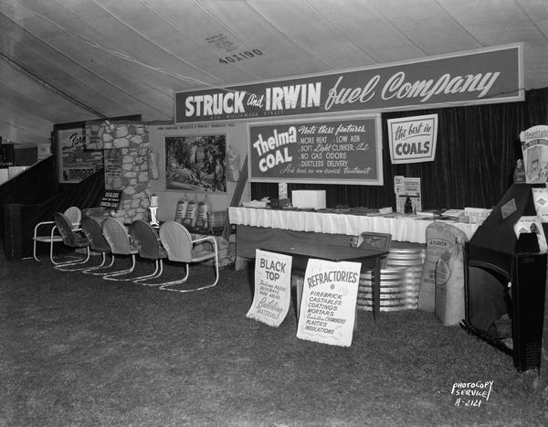 Struck and Irwin Fuel Company booth, at East Side Business Men's Association Fall Festival, in a tent at Olbrich Park, includes charcoal and outdoor charcoal grills, Thelma coal, heatilator display, black top sign with information.