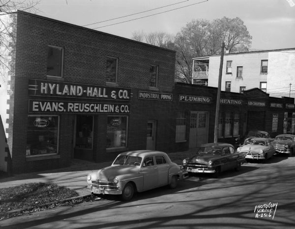 Exterior view of 212-218 North Bassett Street, Hyland-Hall & Company (plumbing, heating and sheet metal contractors) and Evans, Reuschlien & Co., electrical contractors, Division of Hyland-Hall & Co.