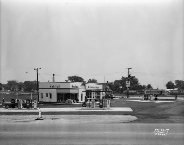 Robert Blossom's Mobil gas station, 3702 East Washington Avenue.  Background includes Mayfair Homes sign and Jacob's Mobile Home Sales, 3715 East Washington Avenue.