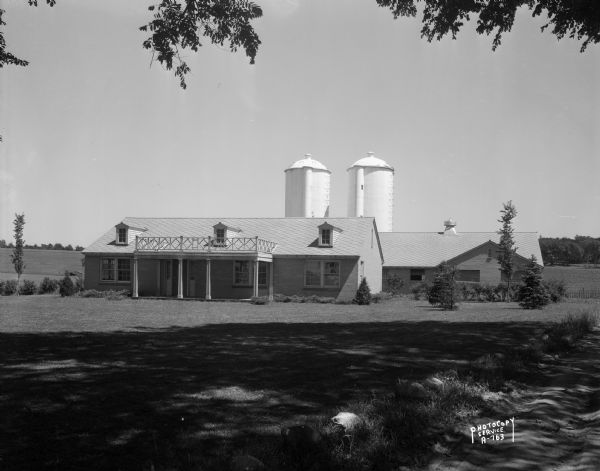 Rennebohm Farm buildings, with house in foreground and barn and silos in background, located five miles from the Capitol, 3787 Highway 151 between Madison and Sun Prairie. The address became 4800 East Washington Avenue, and became site of Del Wood cheese store, (address 5305 Wayne Terrace in 2006). Milk from the farm was used in Rennebohm's soda fountains.