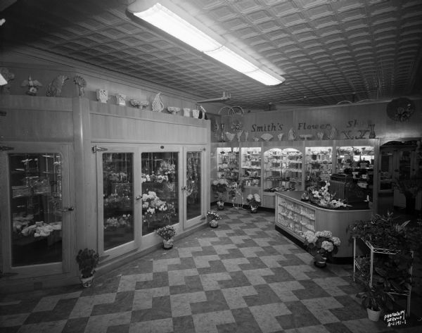 Smith's Flower Shop, 121 State Street, with remodeled interior. Floral coolers with cut flowers, sales counter, shelves with vases and other items. George W. Smith and Dayton K. Smith.