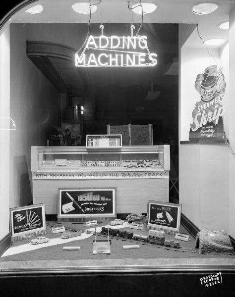 Display window at Rowley & Schlimgen, 540 State Street, featuring Sheaffer's pen and pencil sets "for school days and career years" and a model train layout, "With Sheaffer you are on the right track".