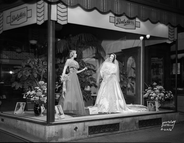 Rentschler Floral Company, 228-230 State Street, with two mannequins wearing bride and bridesmaid gowns, and a floral display in the background.