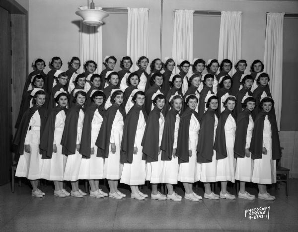 Group portrait of St. Mary's School of Nursing graduates in uniform with capes, at St. Mary's Hospital, 720 South Brooks Street.