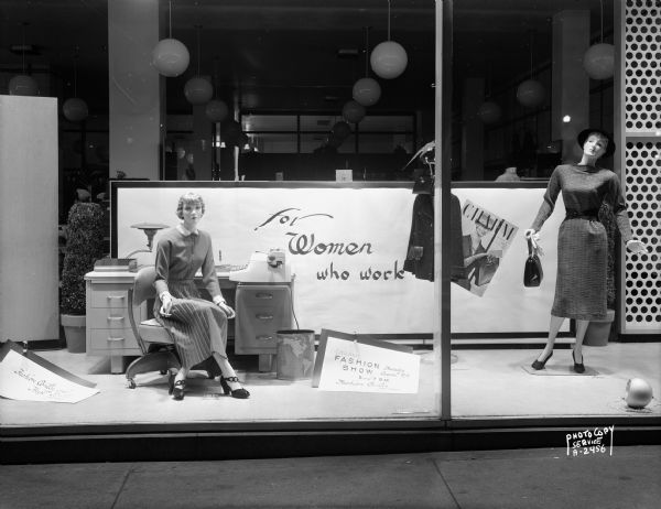 Manchester's, Inc., display in Window B featuring clothing for "Women Who Work" with two mannequins and an office desk.