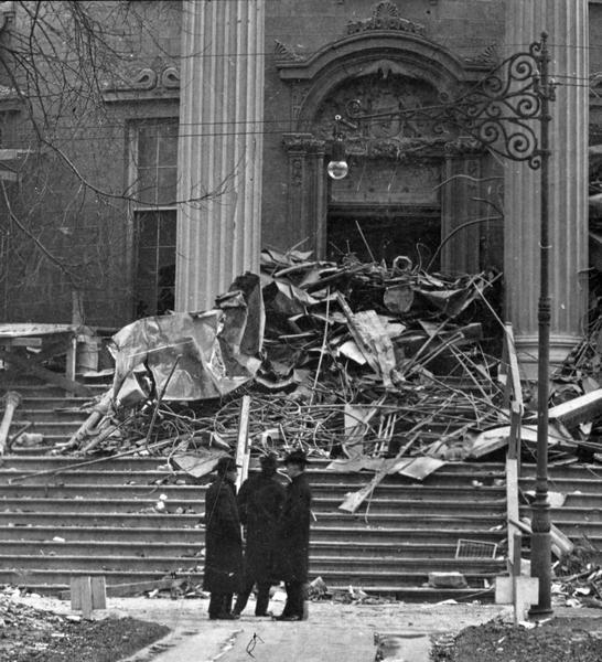 Aftermath of the Wisconsin State Capitol fire of February 26-27. This image provides the best of only a few known photographs of the ornamentation of the west entrance. Above the door, although somewhat obscured, is the state seal.