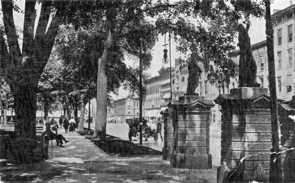 This card which is postmarked 1912 shows the zinc statutes on the stone gateways near the sidewalk at Monona Avenue (now Martin Luther King Jr. Blvd.). Originally constructed in 1873, the statues continued to grace the Capitol Square until the completion of the Fourth Capitol.