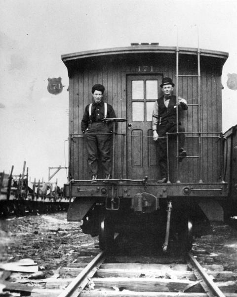 Brakeman Clarence Commingore (left) and Philip C. Haag on Wisconsin Central Railroad's caboose No #171. The shield caboose markers were exclusive with the Wisconsin Central.