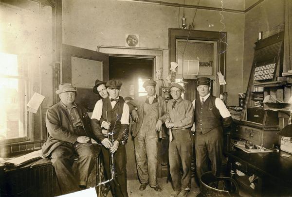 The office of the Minneapolis, St. Paul, and Sault Ste. Marie Railroad. Left to right: Bert Spaulding, an Owen business man; mail clerk Frank Dick; L.H. Ludowise, operator; C.A. Wendt, helper and later a warehouse foreman at Eau Claire; Arthur Wolfram, car clerk; and W.H. Clausen, agent, and later superintendent at the Chicago terminal.