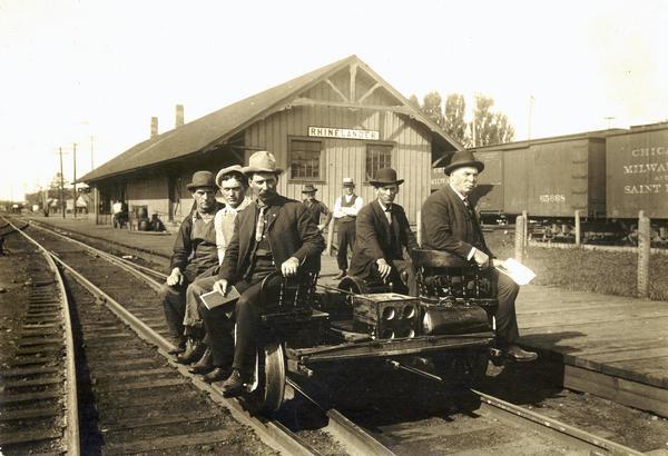 An early gasoline-powered handcar being used on the Minneapolis, St. Paul, & Sault Ste. Marie line for an inspection tour. The employees are (left to right): Frank L. Fisher, B.&B. laborer; Dan McCormick, foreman; an unknown engineer; Superintent B. & B. Alex Amos. Note: the two men at the front of the car are seated in captain's chairs.