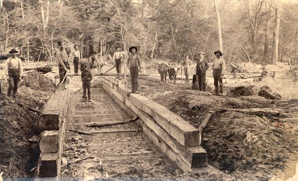 Men building a culvert on the Milwaukee, Lake Shore & Westerm railway. In the background both horses and oxen teams are being used.