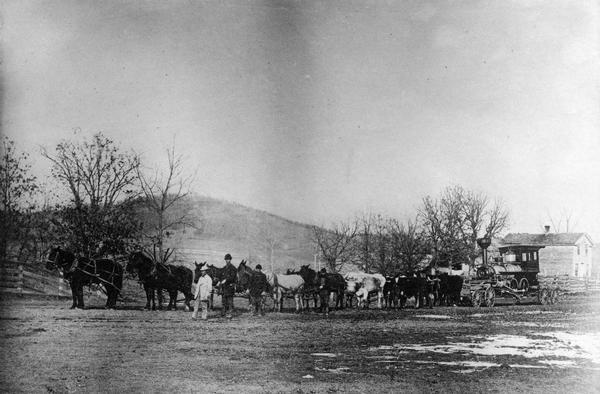 The first locomotive for the Pine River & Stevens Point ralroad, which was purchased in 1875, being hauled overland from Lone Rock to Richland Center while the railroad was under construction.