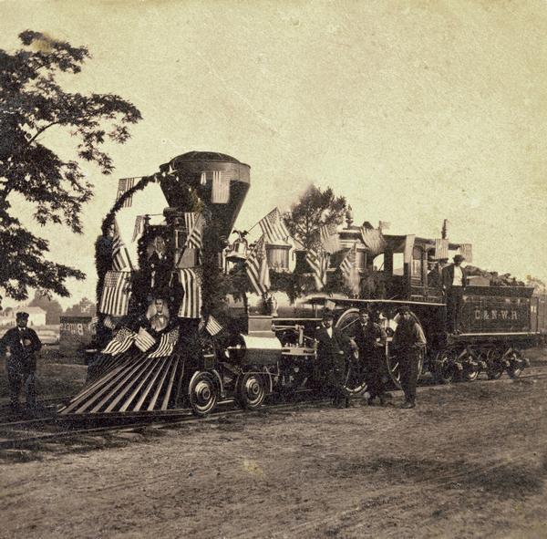 The <i>Camilla</i>, a wood-burning locomotive that belonged to the Chicago & Northwestern Railway. The locomotive is decorated for the 4th of July, 1869.