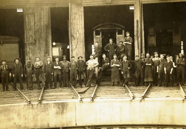 Employees of the Wisconsin and Michigan Railroad posing in the roundhouse.