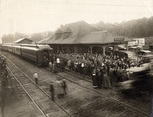 Elevated view of the departure of the drafted soldiers at the Menomonie railroad station, with a crowd present to see them off.