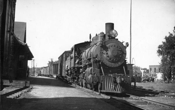 A Wisconsin & Michigan Railroad pulling into the station at Marinette. The conductor on the step has been identified as Ray Campbell.