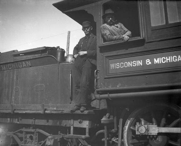 An unidentified engineer and fireman in the cab of a Wisconsin & Michigan locomotive.