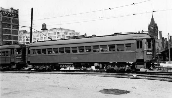 A commuter train of the Milwaukee, North Shore & Milwaukee Railroad, with the tower of Milwaukee's Union Station in the background. The Milwaukee, North Shore & Milwaukee provided high speed service between Chicago and Milwaukee, with hourly departures from both downtown terminals. Service began in 1908, with the high speed service initiated in 1926. At the time this picture was taken the route was in its decline. The railroad ceased operations in 1963.