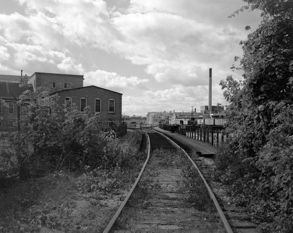 View down railroad tracks towards the railroad bridge, with industrial plants on Doty Island.