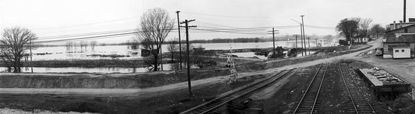 A panoramic view of the Mississippi River flooding during the spring, showing the dykes built along the Chicago, Burlington & Quincy Railroad tracks at Second Avenue.