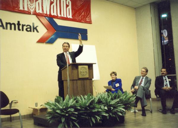 Tommy G. Thompson, governor of Wisconsin and an enthusiastic member of the Amtrak governing board, salutes the expansion of Hiawatha service between Chicago and Milwaukee. The expansion was underwritten by Wisconsin and Illinois. Also taking part in this event is Milwaukee Mayor John Norquist, second from the right.