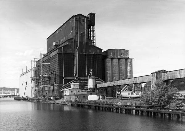 The steel and reinforced concrete grain elevator built by the Great Northern Railroad at Superior about 1900. This contemporary photograph was taken to accompany the elevator's nomination to the national Historic American Engineering Record (HAER). On the left is annex 3, with annex 1 on the right, both of which were built during the 1920s.  Freight cars of the Canadian National Railroad can be seen to the right near the conveyor line, as Canadian oats were the primary use of the elevator at the time this photograph was taken.