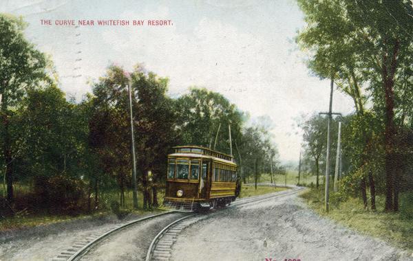 A color postcard depicting the railroad curve near Whitefish Bay resort.