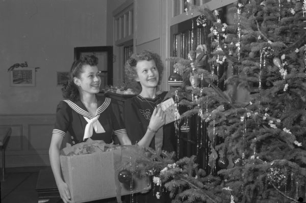 Two young women decorate the Christmas tree at the Madison YWCA.