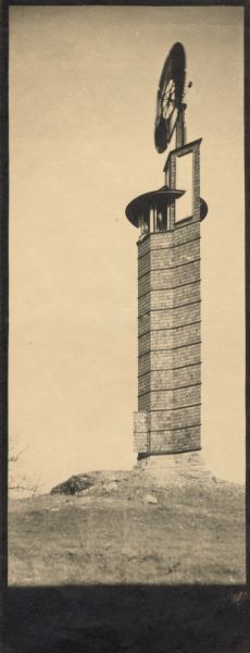 The Romeo and Juliet windmill outside of Hillside Home School, an early progressive school operated by Ellen and Jane Lloyd Jones, aunts of the Frank Lloyd Wright. Two people are looking out of the windows of the tower.