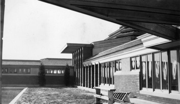 Portions of the rear elevation of the Herbert F. Johnson Residence, "Wingspread," during construction. Portions of the trellis structure and a small corner of the pool are shown. The residence was designed by Frank Lloyd Wright and completed in 1937.
