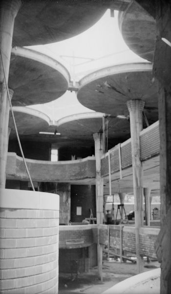 Interior of the two-story work space in the Johnson Wax Building during construction looking up to the ceiling. The building was designed by Frank Lloyd Wright.